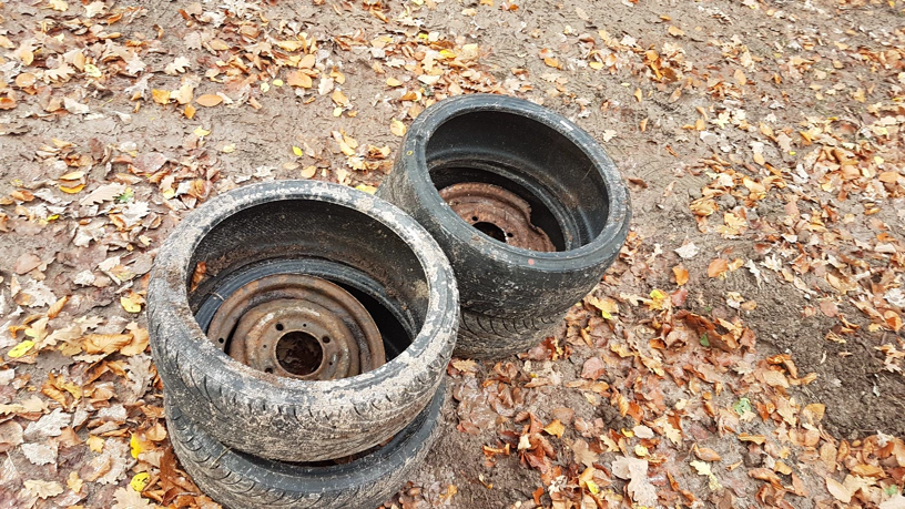 Je zwei Autoreifen liegen aufeinander und darin jeweils eine Autofelge.