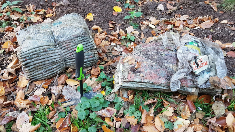 Zwei Stapel gebunden Zeitschriften liegen auf dem Waldboden.