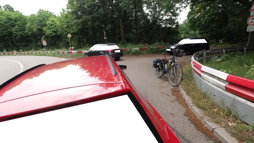 Helmperspektive. Vor mir das Auto, das wir zu dritt die Landstraße hinauf schieben. Dahinter die Einmündung mit den anderen beiden Fahrzeugen und meinem Fahrrad.