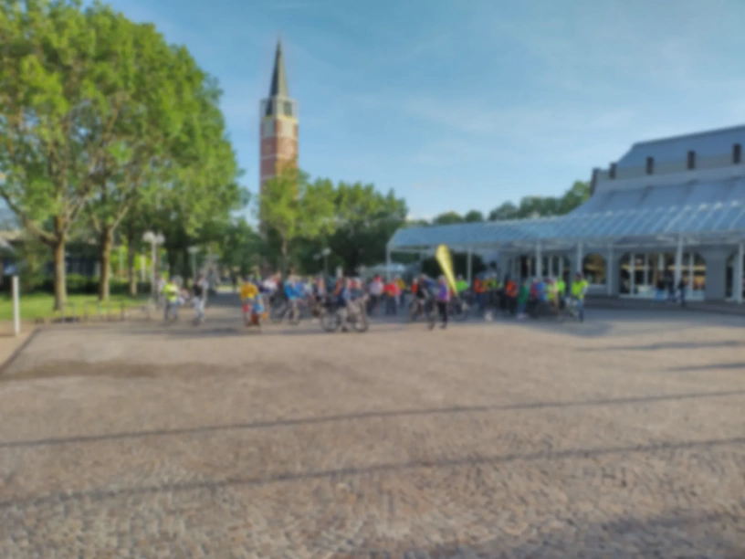 Viele Radfahrende auf einem großen Platz. Das Foto ist unscharf.