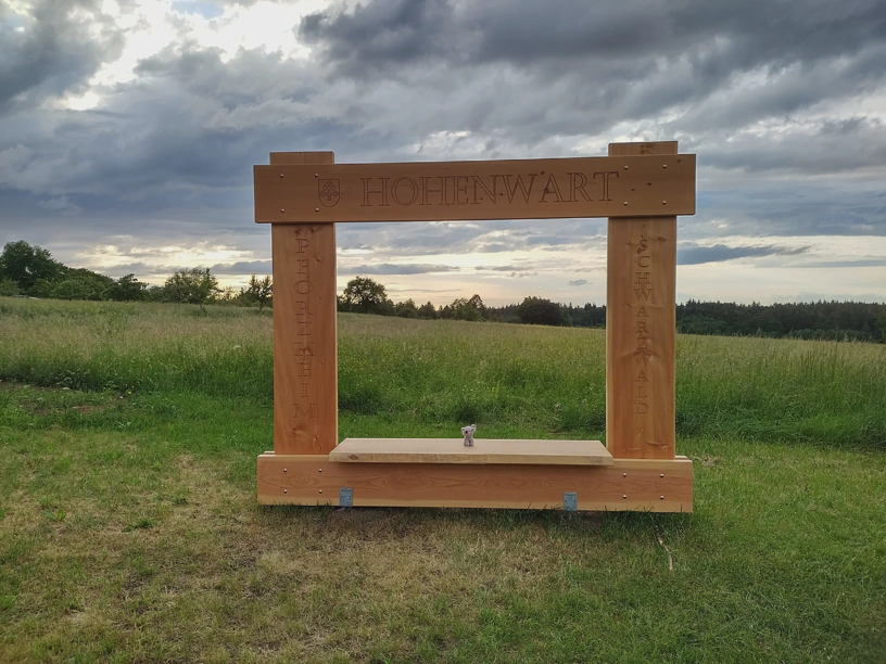 Der kleine Elefant sitzt im Hohenwarter Fotorahmen. Es ist bewölkt und der Himmel ist grau.
