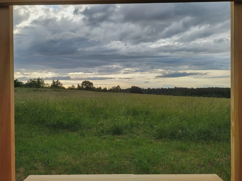 Hohenwarter Fotorahmen, man sieht aber nur das Holz außen im Bild und die Landschaft und den grauen, bewölkten Himmel.