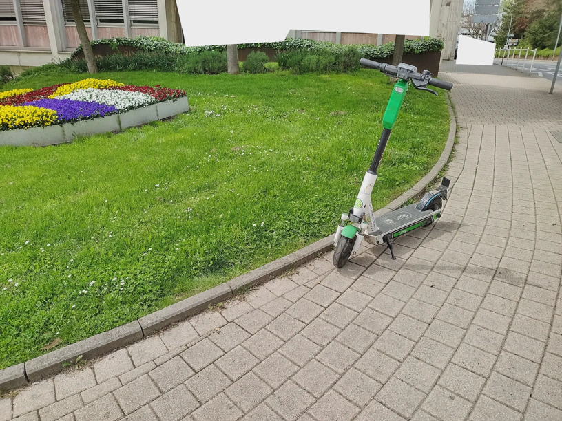 E-Roller steht auf einem Geweg.