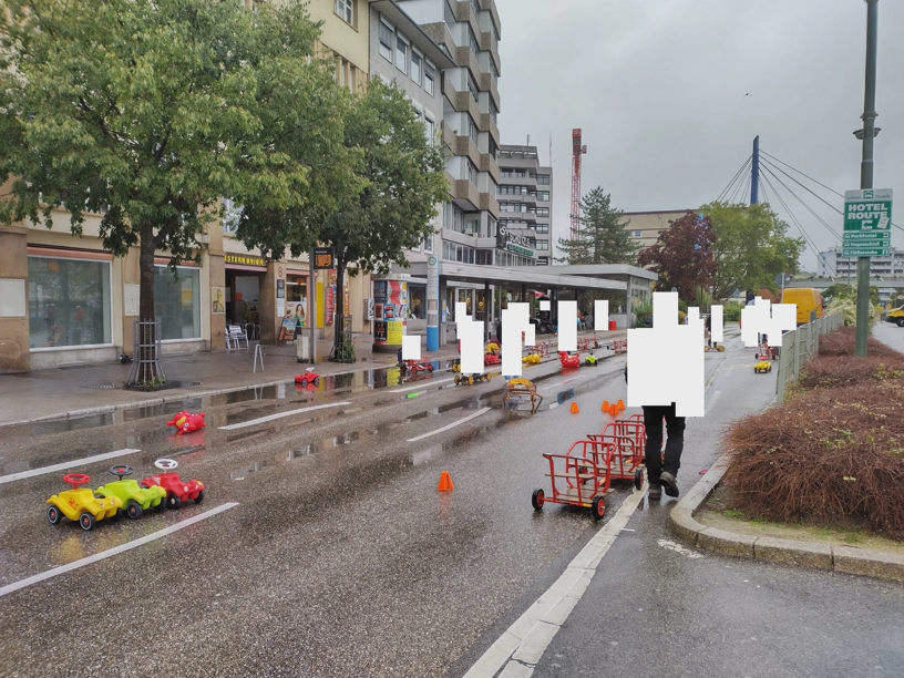 Fahrbahn mit Menschen und verschiedenen Spielgeräten.